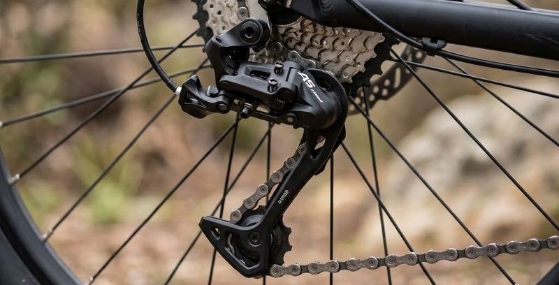 Detalhe do câmbio traseiro, cassete e corrente instalados na transmissão de uma bicicleta.