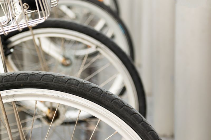 Detalhe de rodas e pneus de bicicletas alinhadas, com foco no pneu dianteiro.